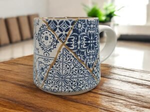 La Taza Amrani de cerámica · 300 ml está inspirada en los azulejos mediterráneos tradicionales, con un diseño patchwork en tonos azul y blanco que transmite armonía, calma y equilibrio. Ideal para disfrutar de té, infusiones o café con estilo y conciencia.