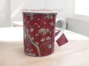 taza-almendro Taza roja de cerámica con diseño de almendro en flor, con filtro interior y tapa, ideal para preparar té e infusiones a granel, capacidad 250 ml.