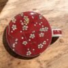 taza-tapa-almendro Taza roja con almendro y filtro para té, con tapa y capacidad de 250 ml. Ideal para infusiones a granel y rituales de té en Ecolivo Natural