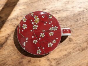 taza-tapa-almendro Taza roja con almendro y filtro para té, con tapa y capacidad de 250 ml. Ideal para infusiones a granel y rituales de té en Ecolivo Natural