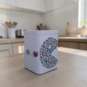 lata-comecocos-100gr Lata comecocos para té 100g con diseño ilustrado de tazas y cierre metálico para conservación.