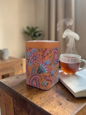 Lata naranja para té 100g con diseño floral tipo mandala y cierre metálico hermético.